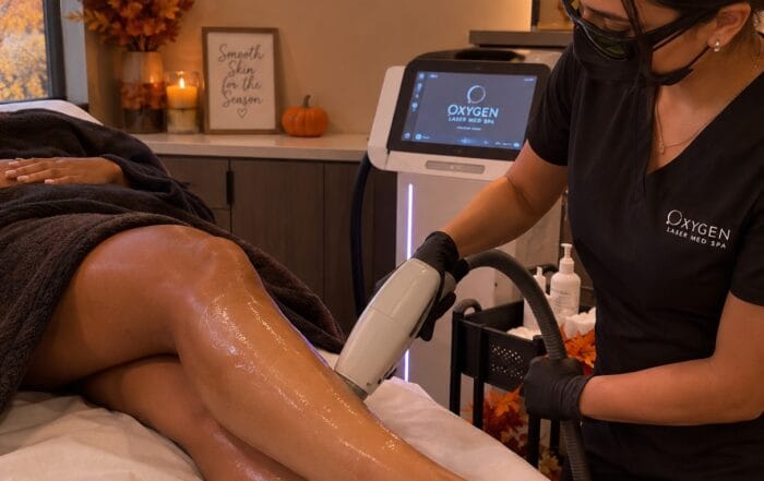 Laser hair removal leg treatment at Oxygen Laser Med Spa in Orland Park, with fall-themed decor including pumpkins and autumn leaves in the treatment room
