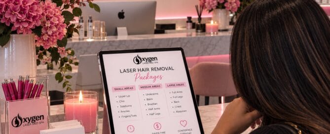Client reviewing laser hair removal package options on a tablet display at Oxygen Med Spa in Orland Park